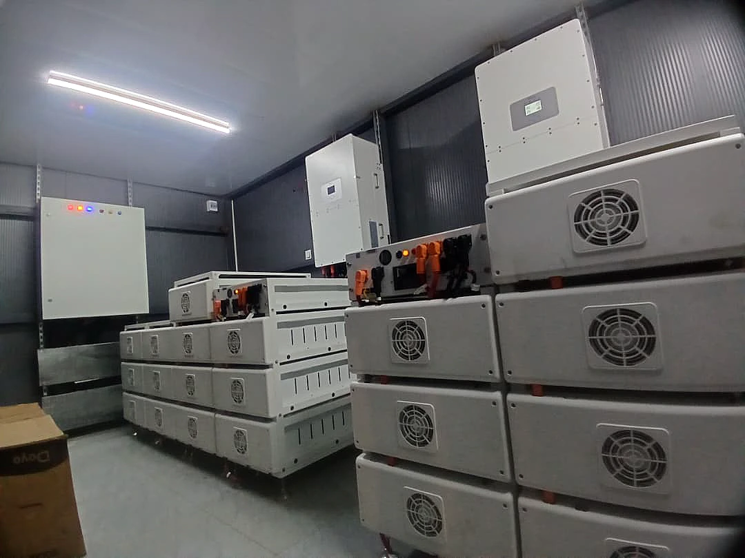 Battery modules stacked in a purpose built plant room with hybrid inverters on the wall