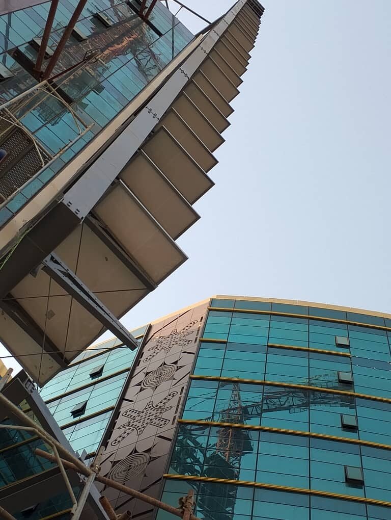 Facade-mounted panels standing off the glass curtain wall