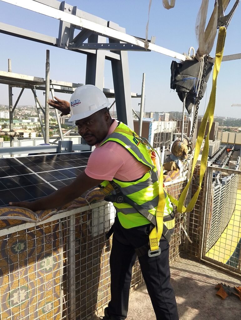Installer in hi-vis fixing a panel at height on the structure