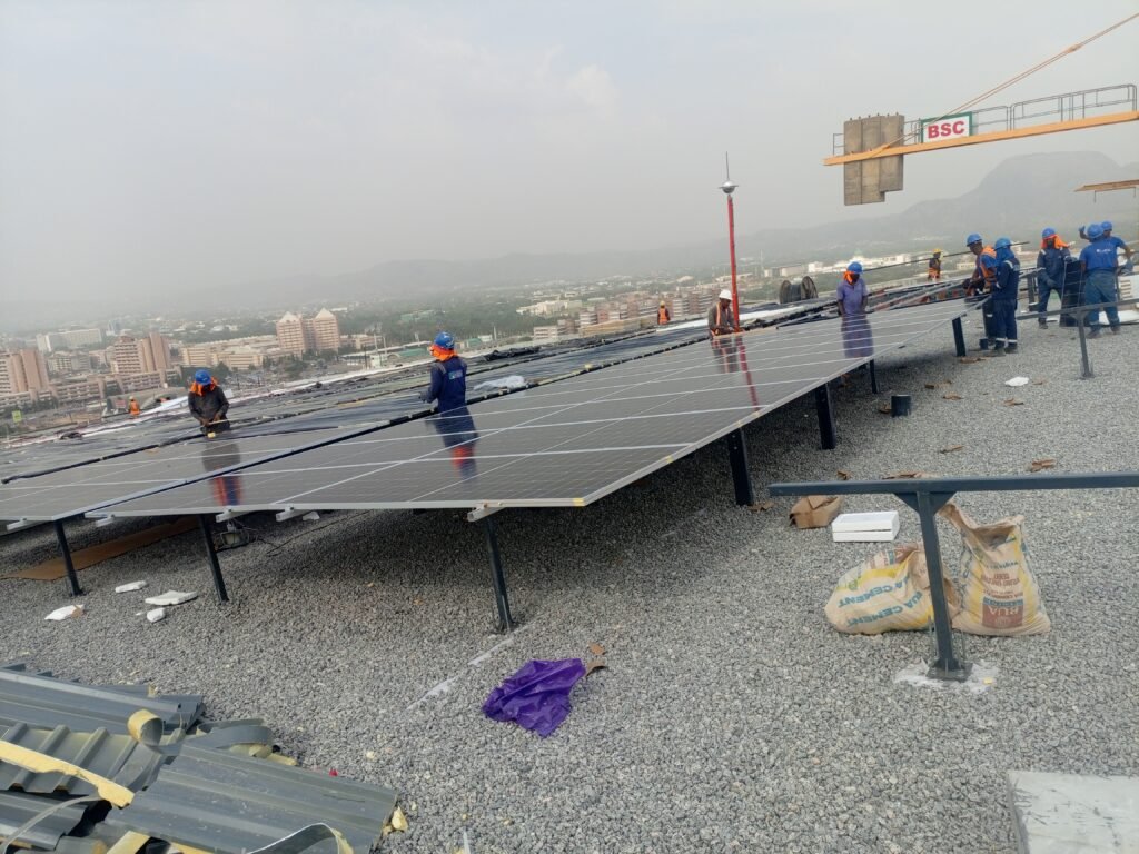 Installed panels on tilt frames with the crew working along the array