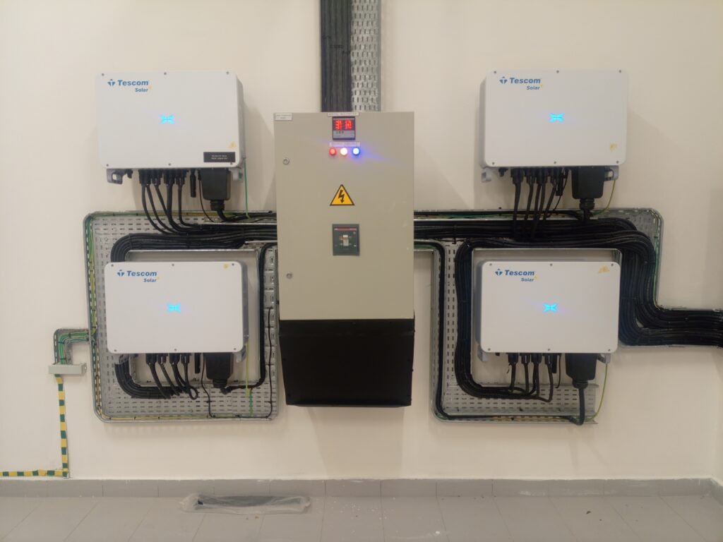 Wall-mounted inverters and control panel in the plant room, conduit dressed to each unit