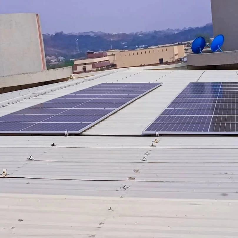 Installer tightening a panel clamp on a roof