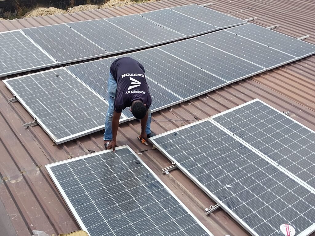 Installer positioning solar modules on a pitched tile roof
